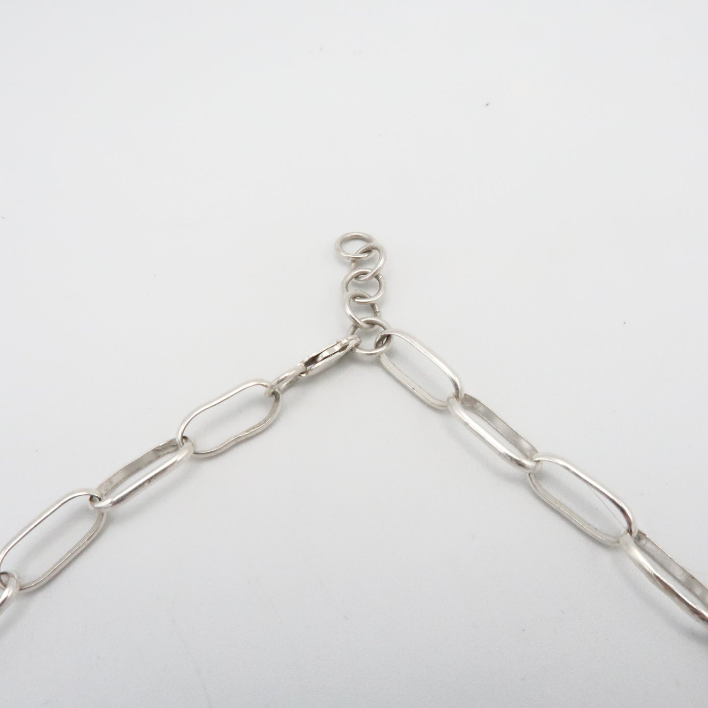 Silver chain necklace on a light gray background