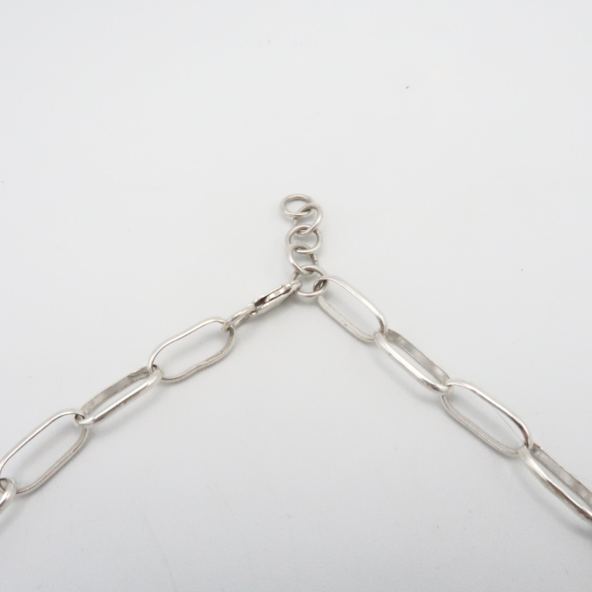 Silver chain necklace on a light gray background