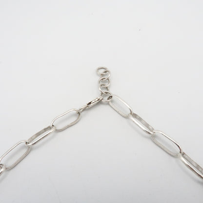 Silver chain necklace on a light gray background