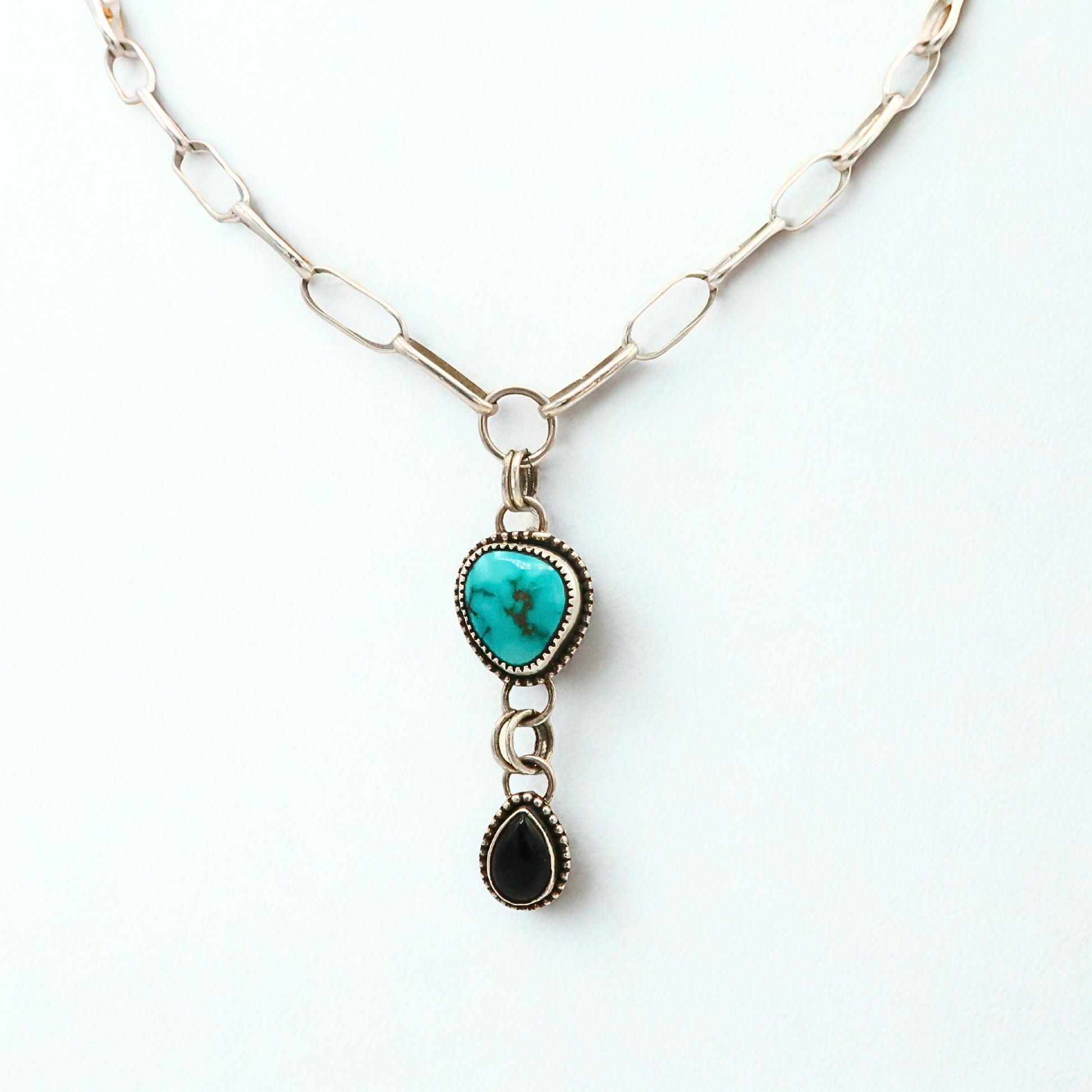 Necklace with turquoise pendant and black Onyx pendant on a white background